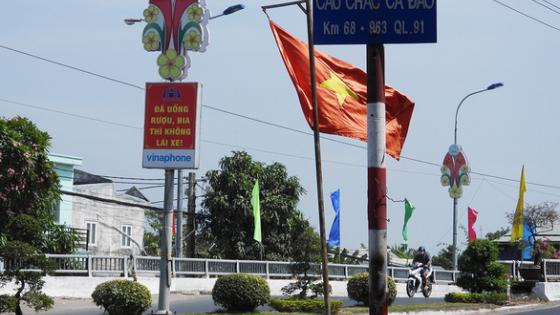 Một chiếc xe khách của Nhà xe Bách Cơ đang chạy trên Quốc lộ 91 gần khu vực Châu Phú, An Giang