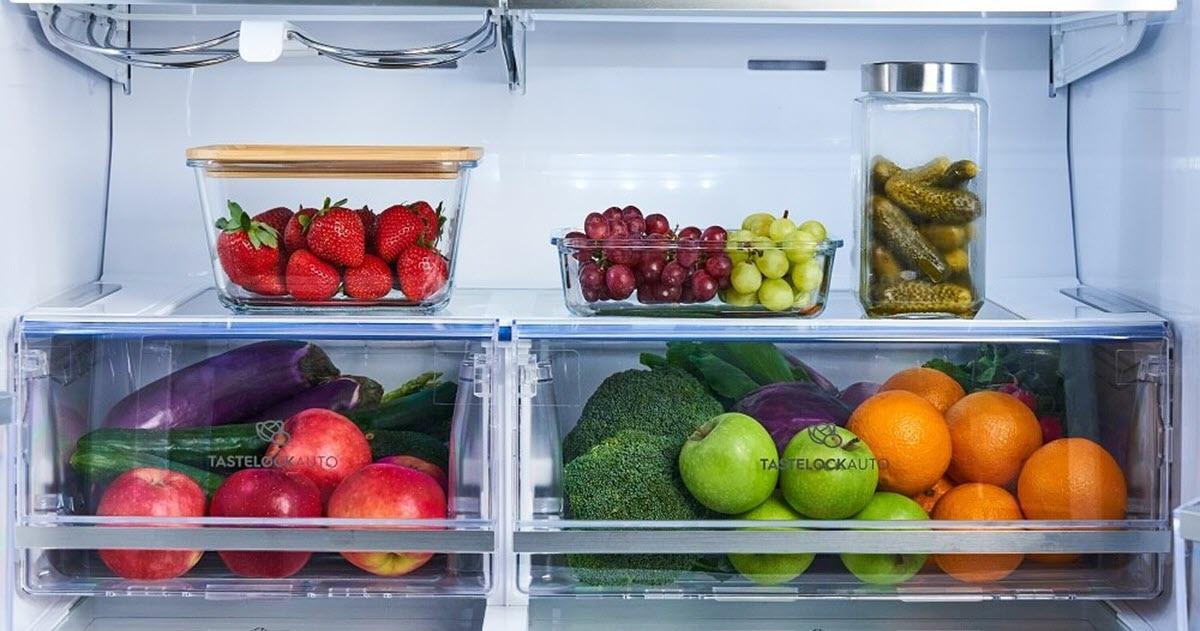 Bàn tay đang lựa chọn những quả cà chua tươi ngon tại một quầy hàng ở chợ nông sản
